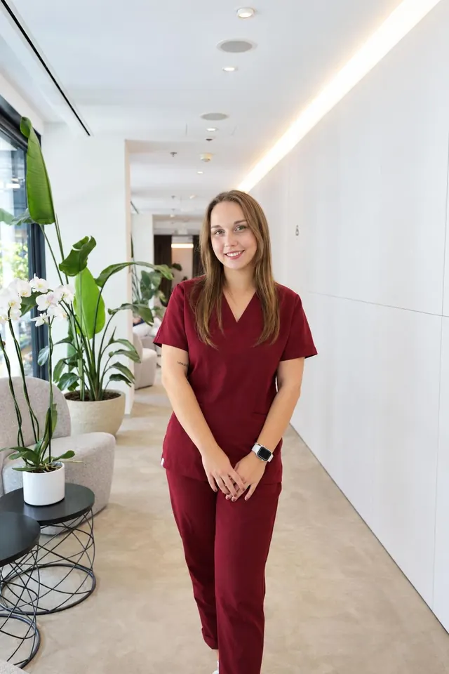 Zdravotná sestra kliniky v bordovej uniforme
